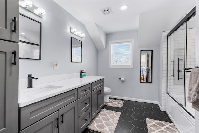 full bathroom featuring tile patterned flooring, vanity, shower / bath combination with glass door, and toilet