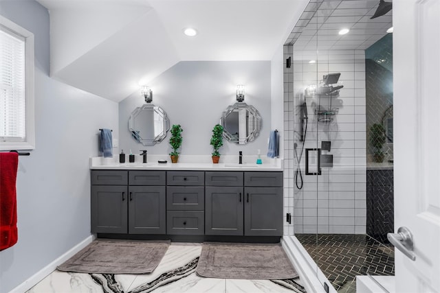 bathroom with a shower with door, vanity, and vaulted ceiling