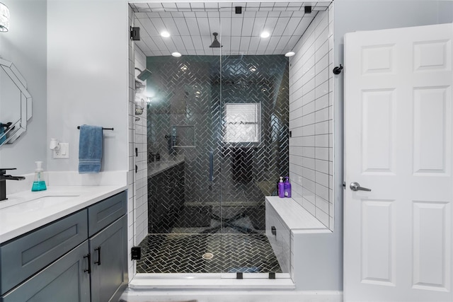 bathroom with a shower with door and vanity