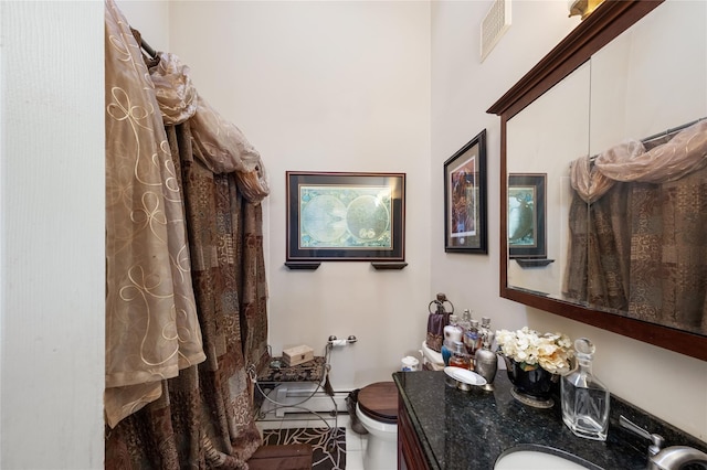 bathroom featuring vanity, tile patterned floors, and toilet