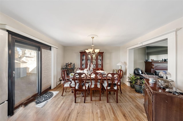 dining area with a chandelier and light hardwood / wood-style flooring