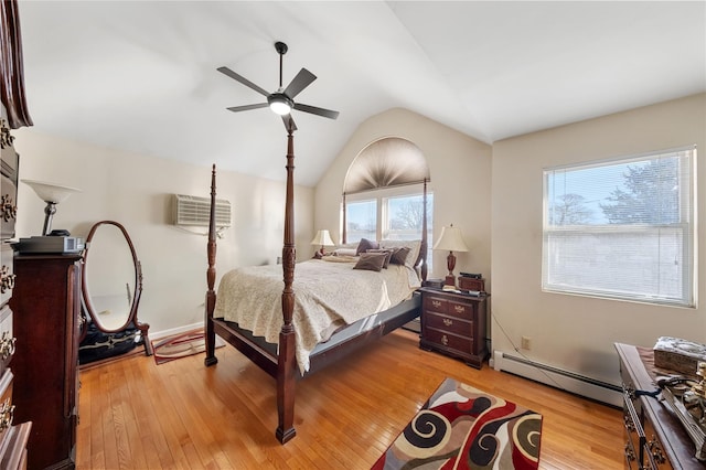 bedroom with ceiling fan, light wood-type flooring, and a baseboard heating unit