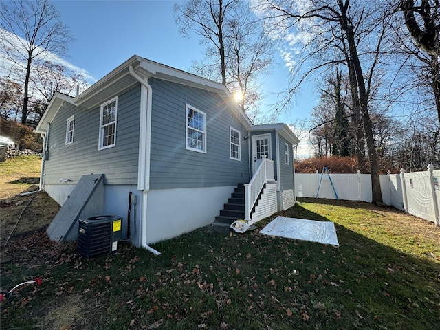 view of property exterior with central AC and a yard