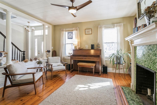 living area with dark hardwood / wood-style flooring, ceiling fan, and ornate columns