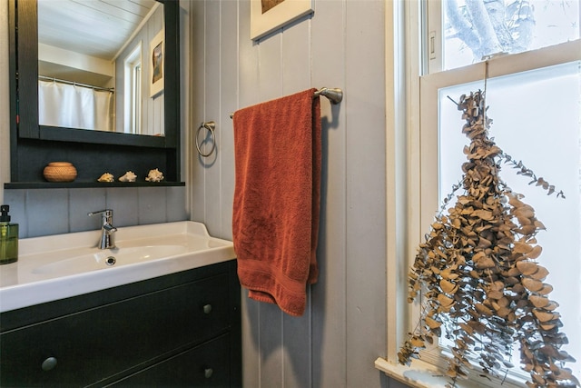 bathroom featuring vanity and wood walls