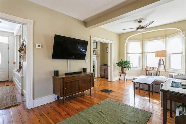 living room featuring beam ceiling, hardwood / wood-style floors, and ceiling fan