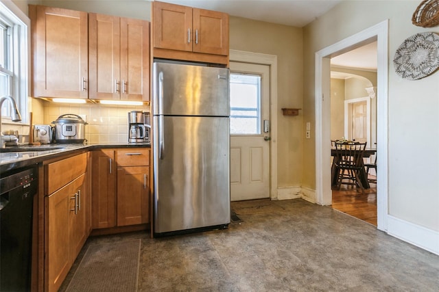 kitchen featuring tasteful backsplash, sink, stainless steel fridge, and dishwasher