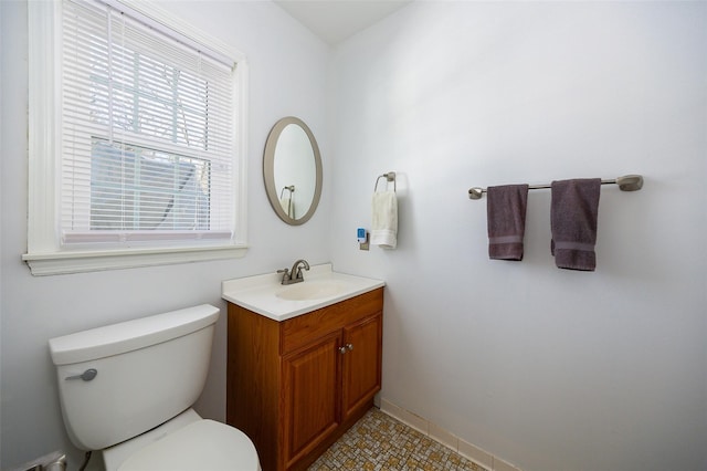 half bath featuring toilet, baseboards, and vanity