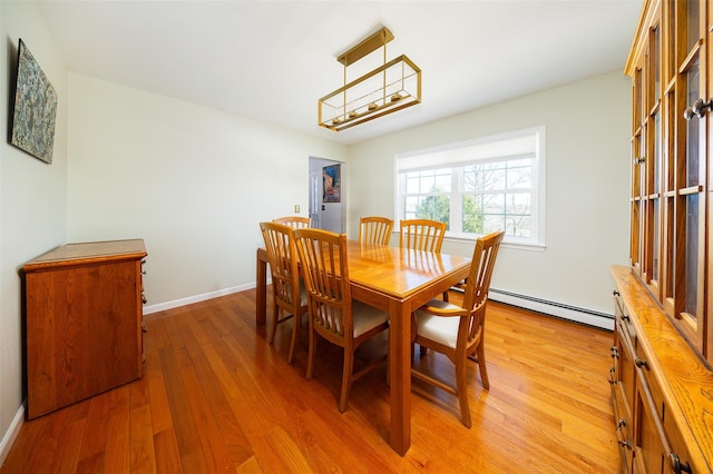 dining room featuring light wood-style floors, baseboards, and baseboard heating