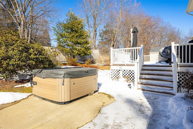 yard layered in snow with a hot tub and a wooden deck