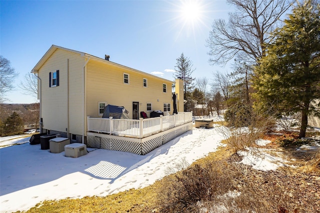 view of snow covered exterior featuring a wooden deck