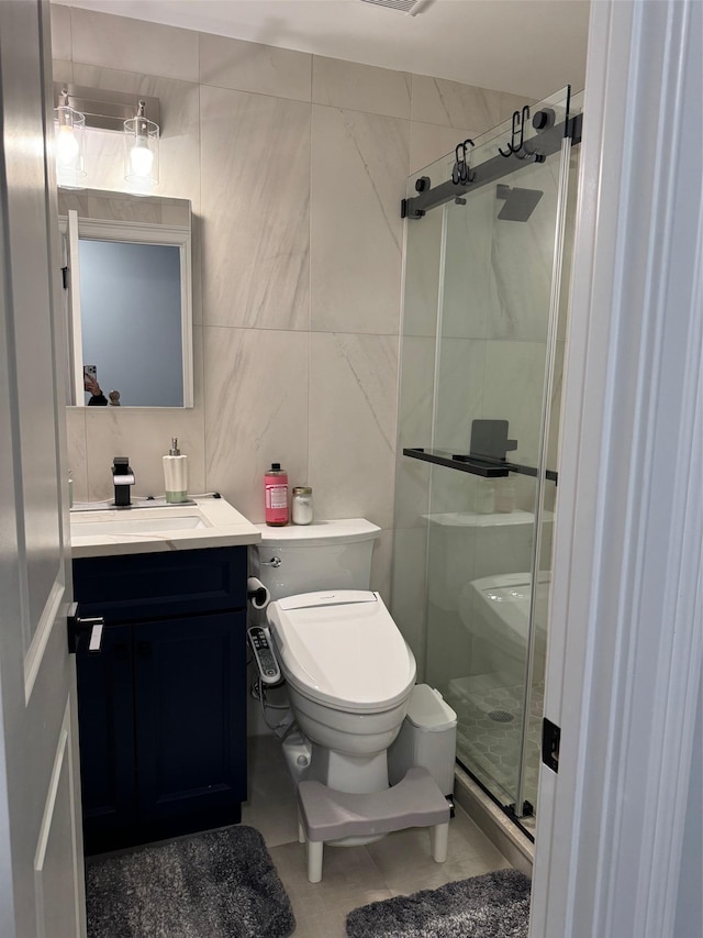 bathroom with vanity, toilet, tile walls, and walk in shower