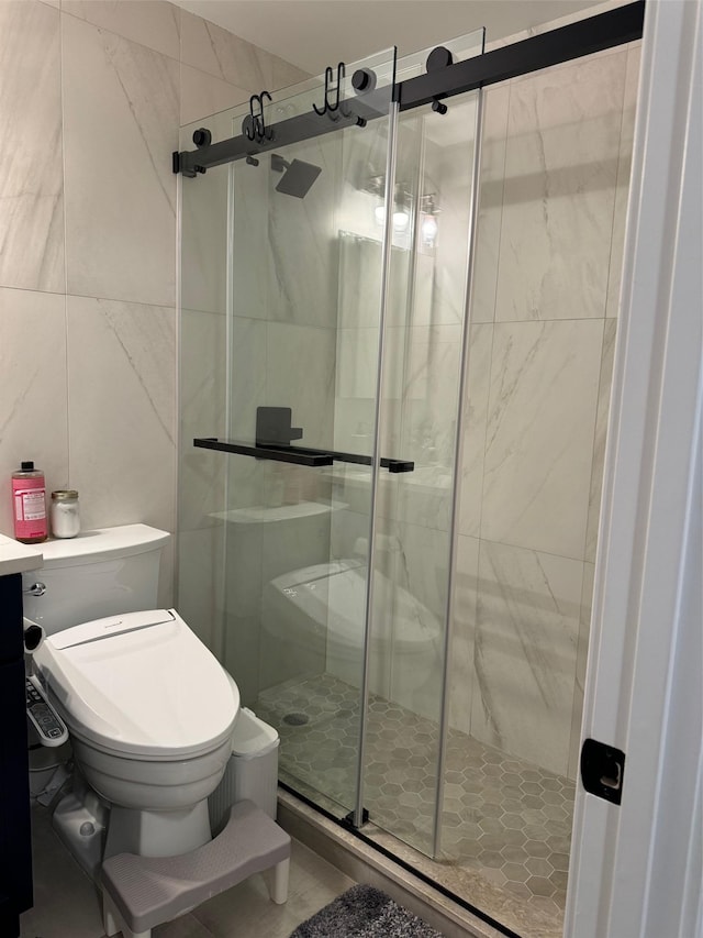 bathroom featuring toilet, a shower with door, and tile walls