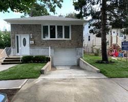 view of front of property featuring a garage and a front lawn