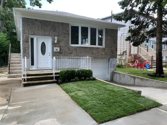 view of front of property featuring a garage and a front lawn