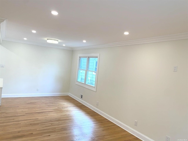 empty room featuring ornamental molding and light hardwood / wood-style flooring