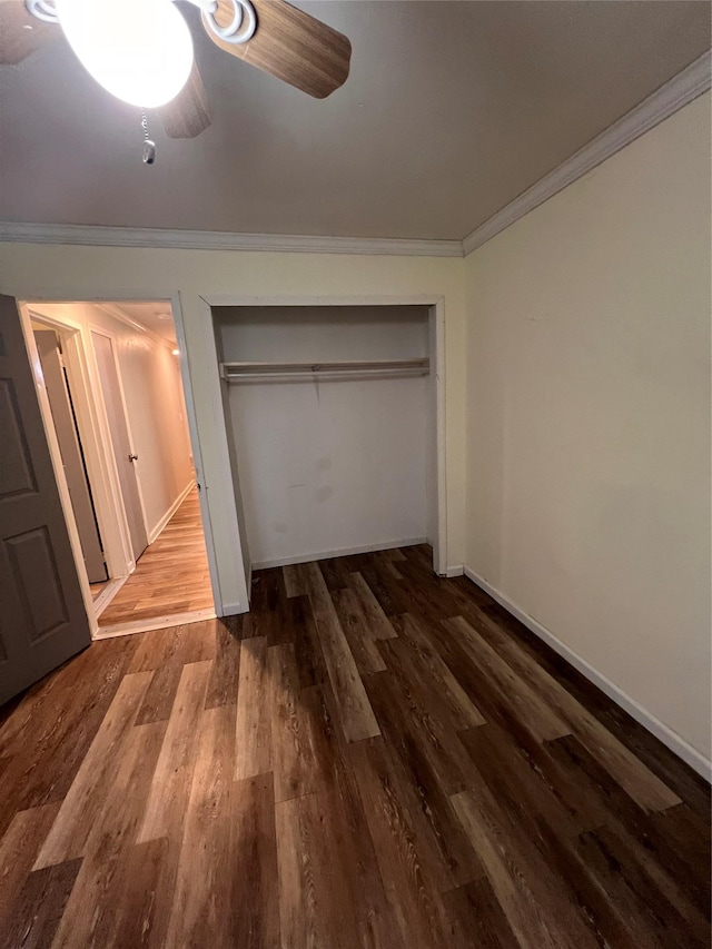 unfurnished bedroom with dark wood-type flooring, ceiling fan, ornamental molding, and a closet