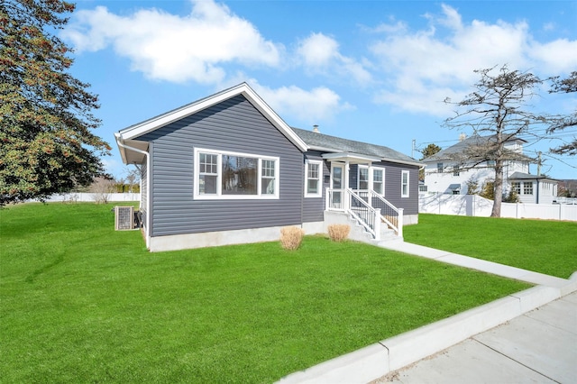 view of front of house featuring a front lawn, cooling unit, and fence