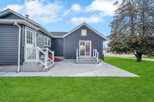 back of house featuring a lawn and a patio area