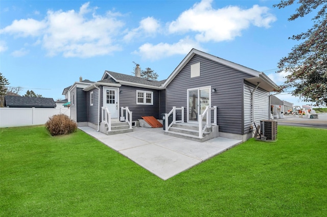 rear view of house featuring fence, cooling unit, and a yard