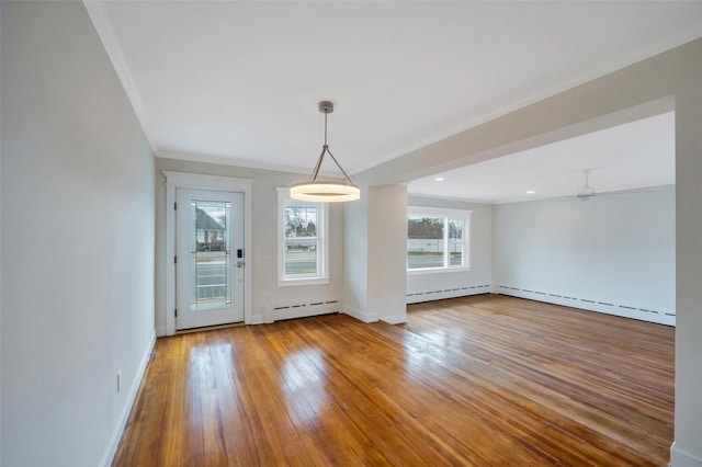 unfurnished dining area featuring a baseboard heating unit, ornamental molding, and hardwood / wood-style flooring