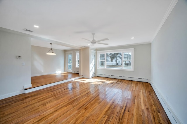 spare room with hardwood / wood-style flooring, visible vents, a baseboard heating unit, and ornamental molding