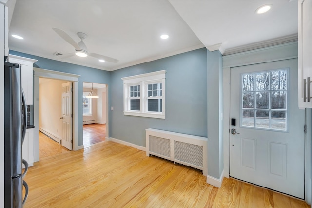 entrance foyer with light wood finished floors, baseboard heating, a ceiling fan, and radiator