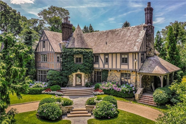 42 Masterton Rd, Bronxville, NY 10708 - tudor-style house featuring stone siding, stucco siding, a chimney, and covered porch