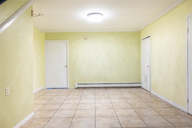 empty room with a baseboard heating unit and light tile patterned floors