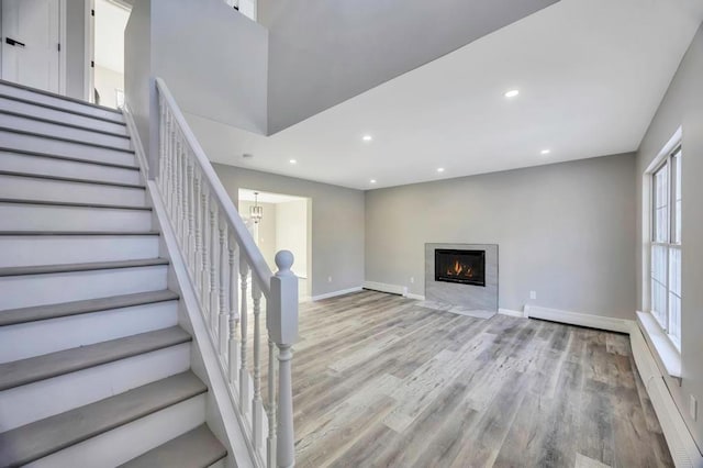 interior space featuring a baseboard radiator, a notable chandelier, and light hardwood / wood-style floors