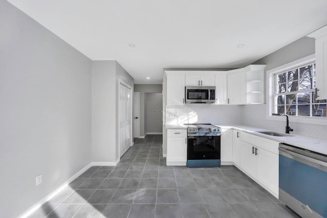 kitchen with white cabinetry, sink, stainless steel appliances, and dark tile patterned floors