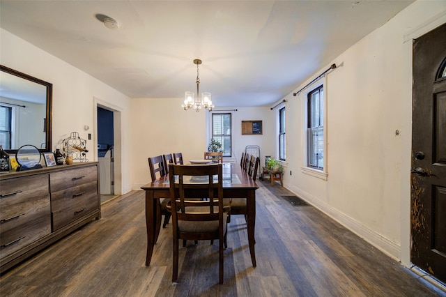 dining room featuring dark hardwood / wood-style floors and a chandelier