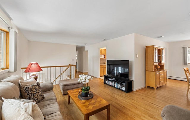 living room featuring a baseboard radiator and light hardwood / wood-style flooring