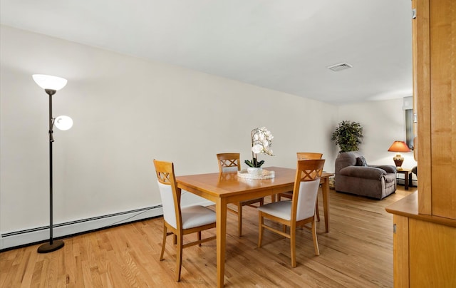 dining room featuring light wood-type flooring and baseboard heating