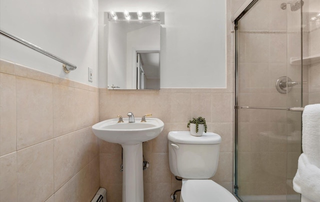 bathroom with tile walls, sink, a shower with door, and toilet