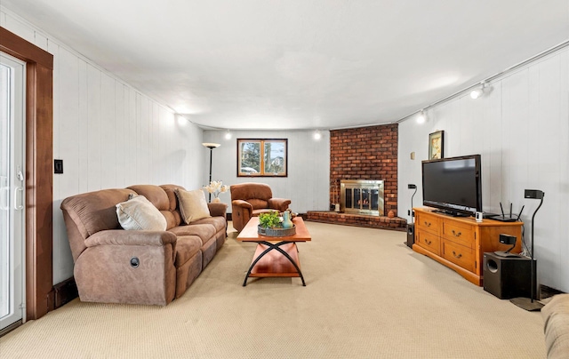 carpeted living room with a fireplace and rail lighting