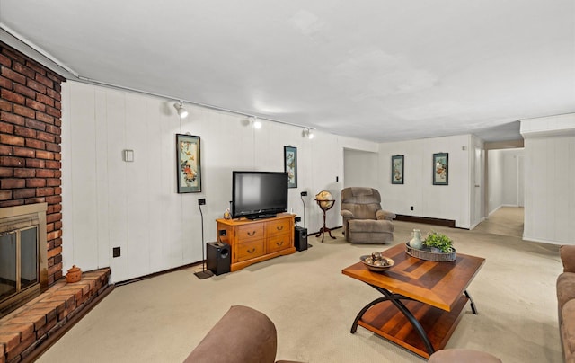 living room with a fireplace, light colored carpet, and track lighting