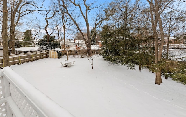 yard covered in snow featuring a storage unit