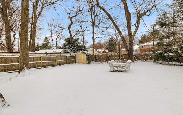 yard layered in snow featuring a storage shed