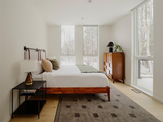 bedroom featuring access to exterior and light wood-type flooring