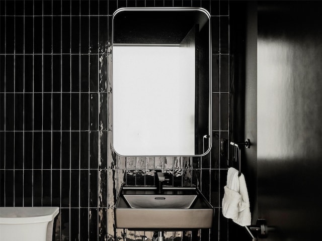 bathroom featuring sink, backsplash, and toilet