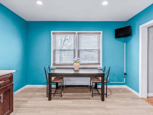 dining area with radiator and light hardwood / wood-style flooring