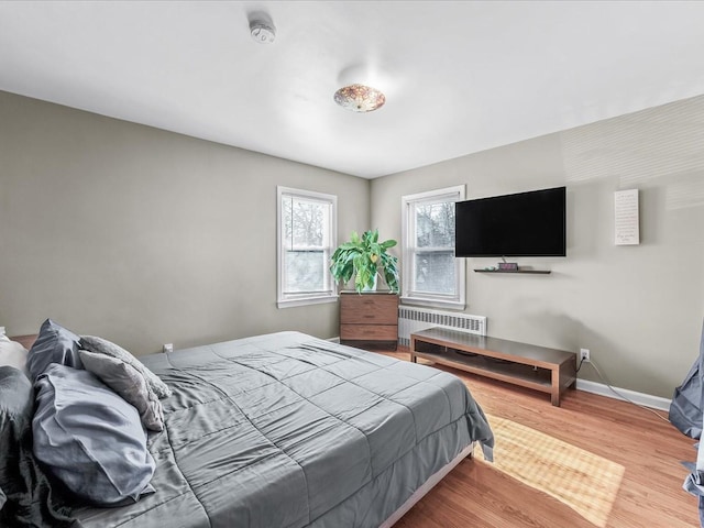 bedroom featuring hardwood / wood-style flooring and radiator heating unit