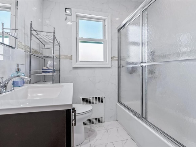 full bathroom featuring vanity, radiator heating unit, tile walls, and toilet