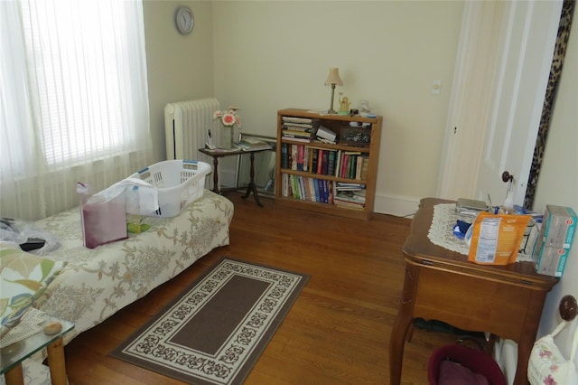 bedroom with dark hardwood / wood-style flooring and radiator