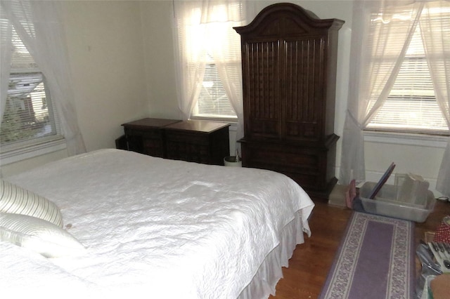 bedroom featuring dark hardwood / wood-style flooring and multiple windows