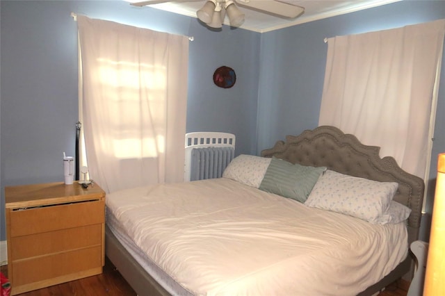 bedroom featuring crown molding, dark wood-type flooring, and ceiling fan