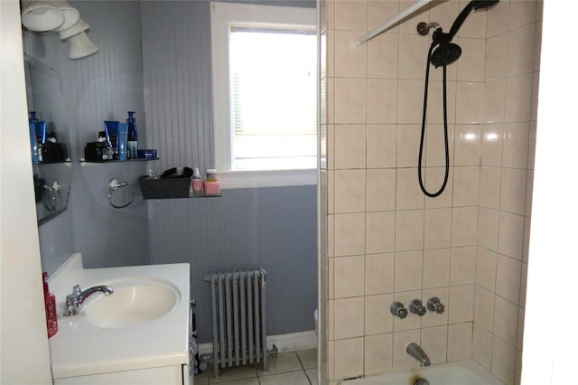 bathroom featuring radiator heating unit, tiled shower / bath combo, tile patterned flooring, and vanity