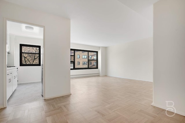 unfurnished room featuring a baseboard radiator and light parquet flooring