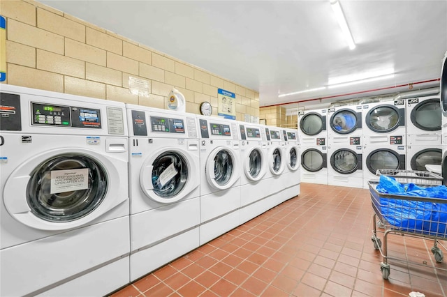 clothes washing area with tile patterned floors, washer and clothes dryer, and stacked washer / drying machine